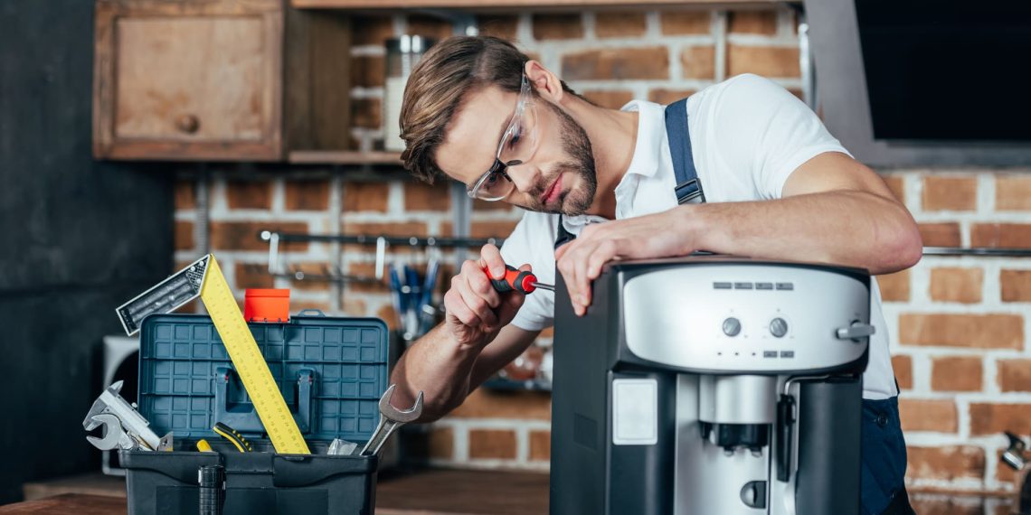 professional-young-repairman-in-eyeglasses-fixing-4EAJD5U.jpg